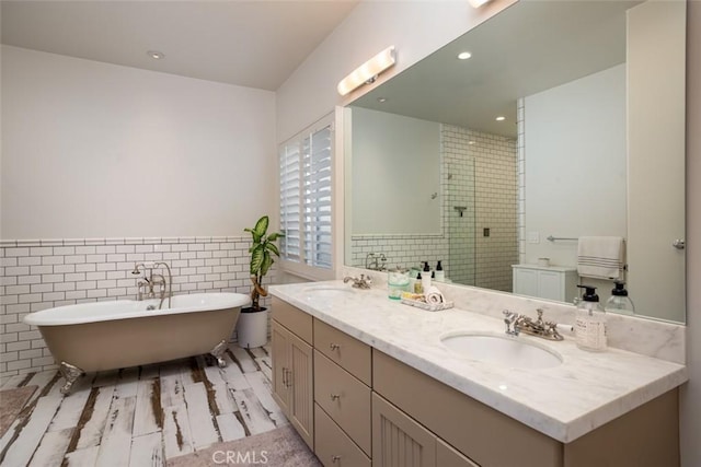 bathroom with shower with separate bathtub, vanity, and tile walls