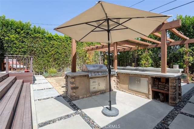 view of patio / terrace featuring an outdoor kitchen, area for grilling, a pergola, and a wooden deck