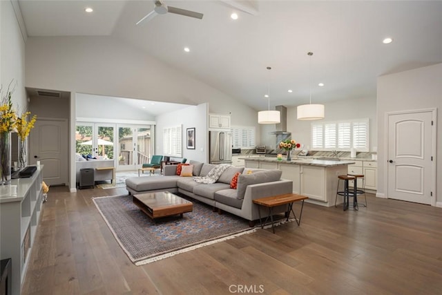 living room with high vaulted ceiling, ceiling fan, and dark wood-type flooring