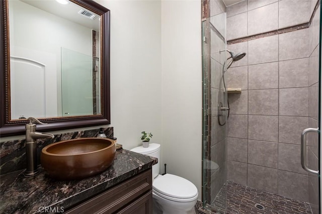 bathroom with walk in shower, vanity, and toilet