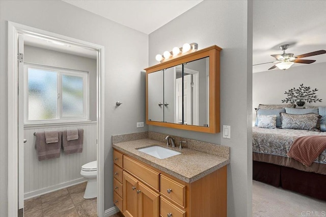 bathroom with toilet, ceiling fan, and vanity