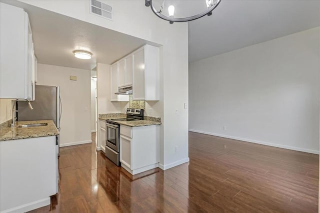 kitchen featuring light stone counters, stainless steel electric range oven, white cabinets, and sink