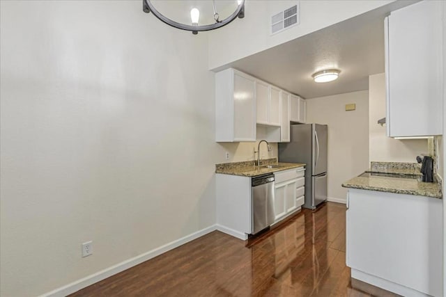 kitchen with white cabinets, stainless steel appliances, sink, and light stone countertops