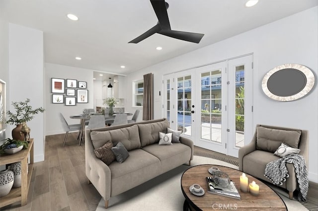 living room featuring ceiling fan, hardwood / wood-style floors, and french doors