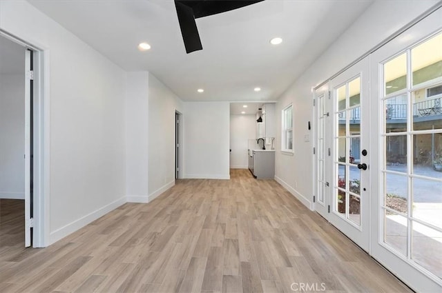 empty room with ceiling fan, light hardwood / wood-style flooring, plenty of natural light, and sink