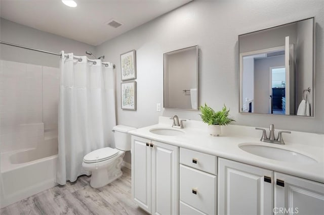 full bathroom featuring hardwood / wood-style floors, vanity, toilet, and shower / bath combo with shower curtain