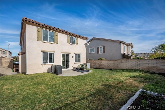 back of property with a lawn and a patio