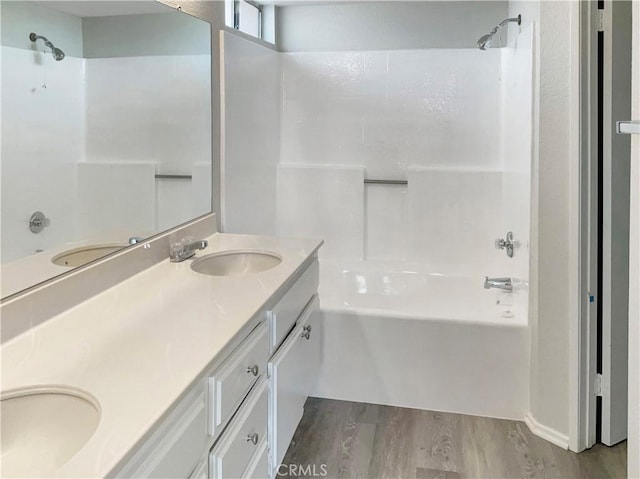 bathroom with shower / bath combination, hardwood / wood-style floors, and vanity