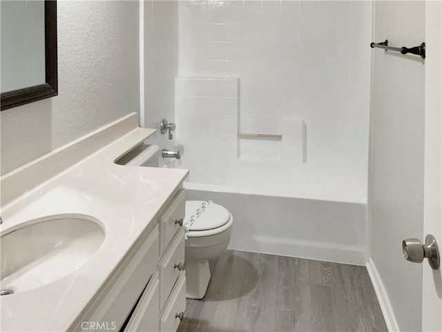 full bathroom with toilet, hardwood / wood-style flooring, vanity, and shower / bathing tub combination