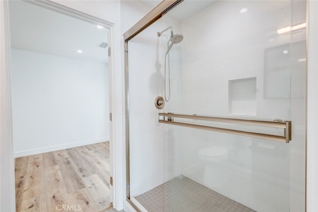 bathroom featuring hardwood / wood-style floors and a shower with door