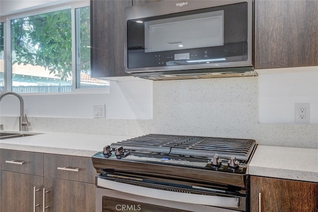 kitchen with dark brown cabinets, sink, and appliances with stainless steel finishes