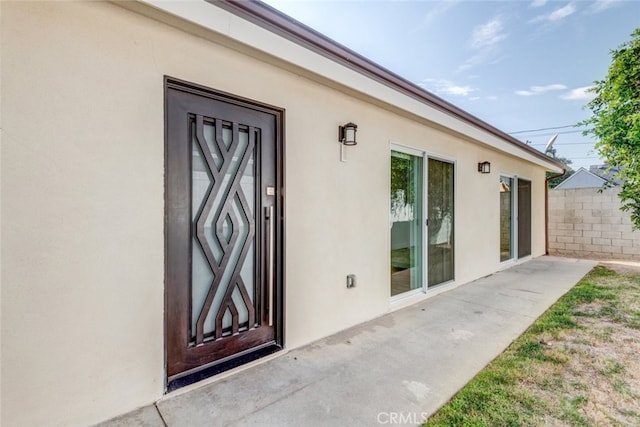 view of exterior entry with a patio area