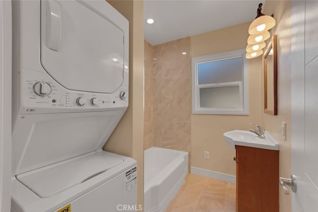 laundry area featuring sink and stacked washing maching and dryer