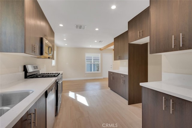 kitchen with appliances with stainless steel finishes, light wood-type flooring, and sink