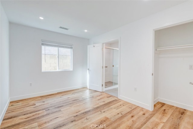 unfurnished bedroom featuring a closet and light hardwood / wood-style flooring