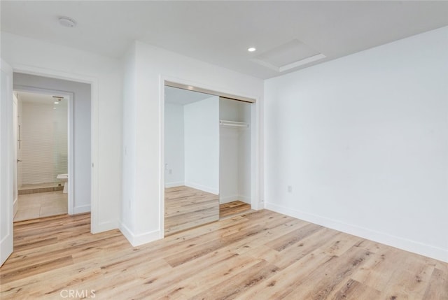 unfurnished bedroom featuring light hardwood / wood-style floors and a closet