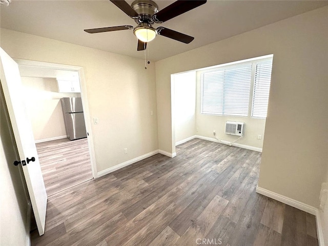 unfurnished room featuring hardwood / wood-style floors, a wall unit AC, and ceiling fan