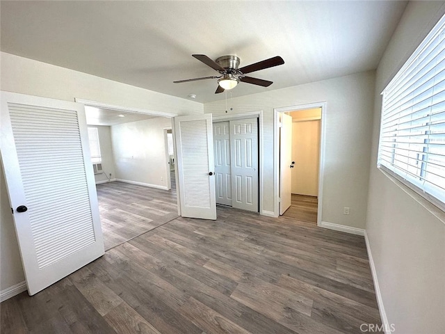 unfurnished bedroom with ceiling fan and dark hardwood / wood-style flooring