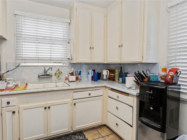 kitchen featuring light tile patterned floors, backsplash, and sink