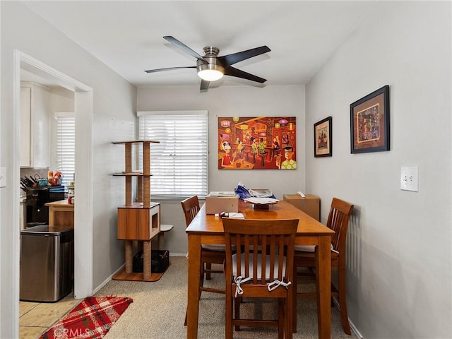 carpeted dining area with ceiling fan