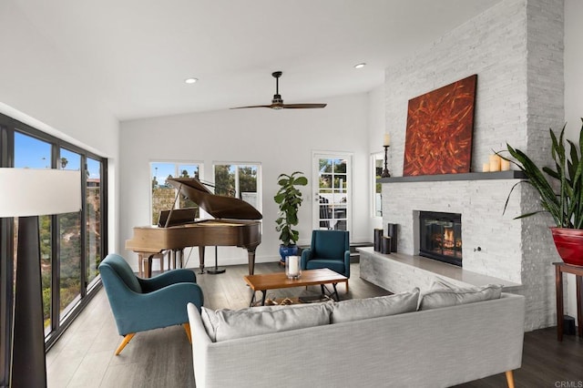 living room featuring ceiling fan, a fireplace, and hardwood / wood-style flooring