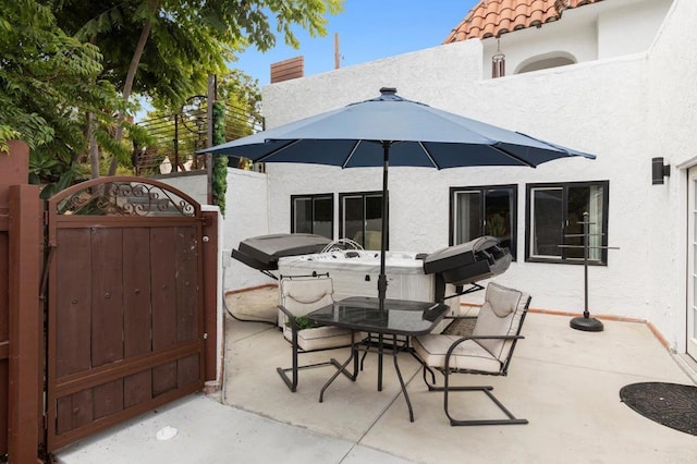 view of patio / terrace with a grill and a hot tub