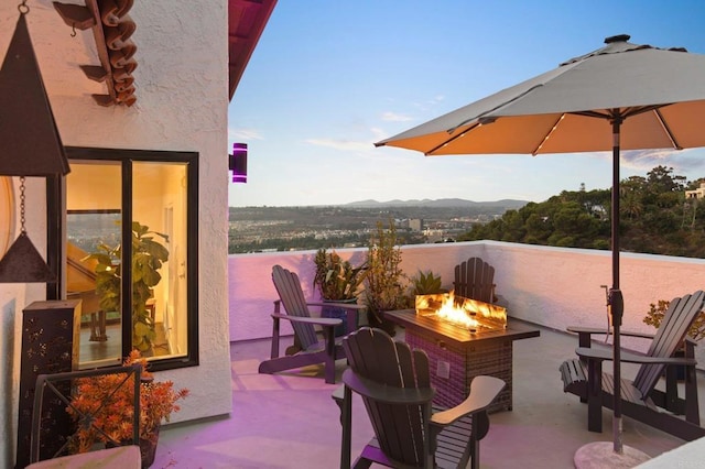 view of patio with a water and mountain view and an outdoor fire pit