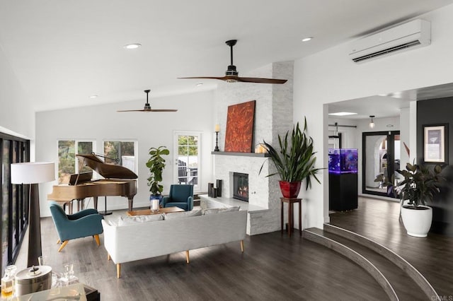 living room featuring an AC wall unit, hardwood / wood-style flooring, high vaulted ceiling, and a fireplace