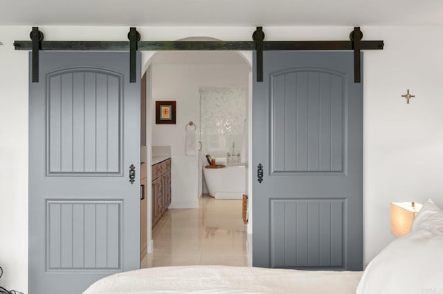 tiled bedroom featuring a barn door