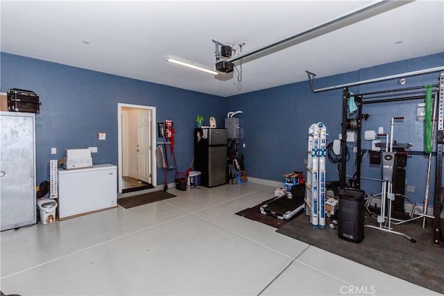 garage featuring a garage door opener and freestanding refrigerator