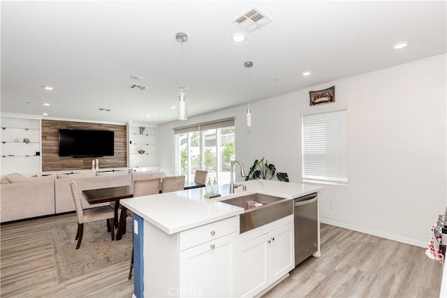 kitchen featuring visible vents, a sink, open floor plan, a center island with sink, and stainless steel dishwasher