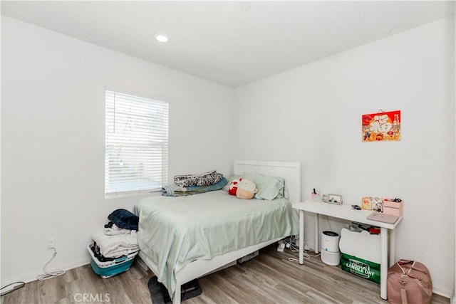 bedroom with wood finished floors and baseboards