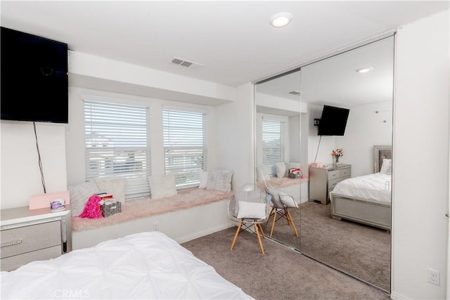 bedroom with a closet, visible vents, baseboards, and carpet