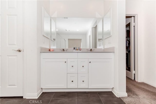 bathroom featuring double vanity, baseboards, visible vents, and a sink