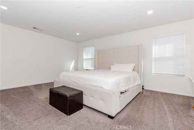 carpeted bedroom featuring recessed lighting, visible vents, and baseboards