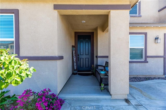 entrance to property featuring stucco siding