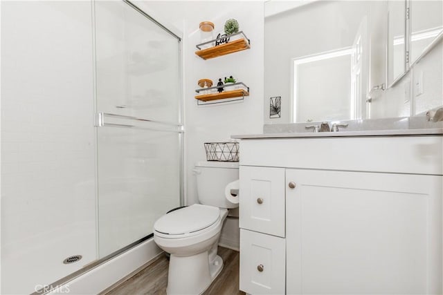 full bath featuring wood finished floors, toilet, a stall shower, and vanity