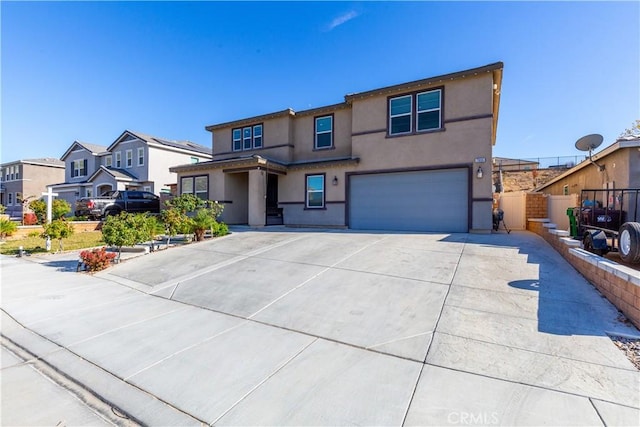 view of front of house featuring fence, a residential view, stucco siding, driveway, and an attached garage