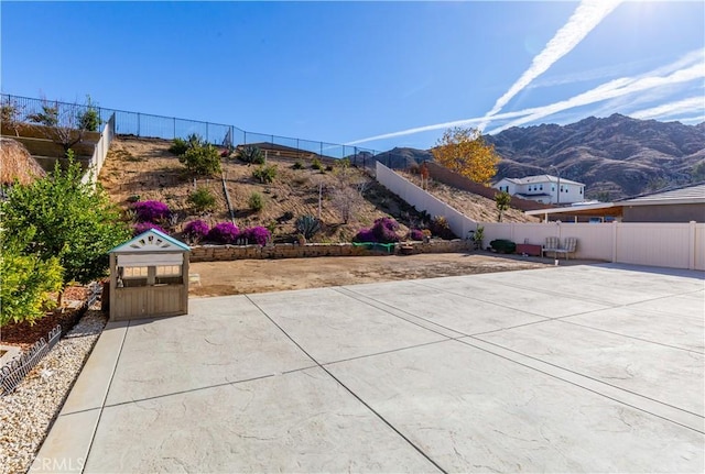 view of patio / terrace featuring fence and a mountain view