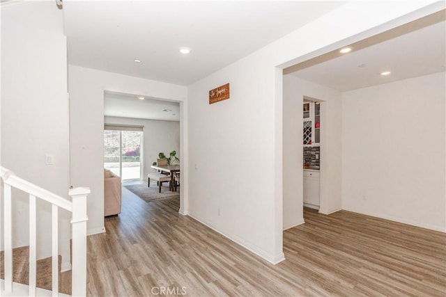 hallway with stairs, recessed lighting, and light wood-style floors