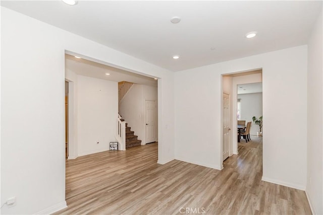 unfurnished room with stairway, recessed lighting, baseboards, and light wood finished floors