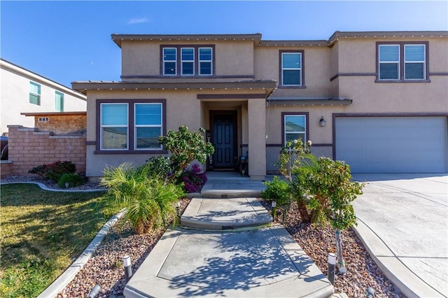 view of front of home featuring stucco siding, concrete driveway, a garage, and a front yard