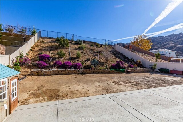 view of yard with a mountain view and a fenced backyard