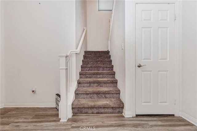 stairs featuring baseboards and wood finished floors