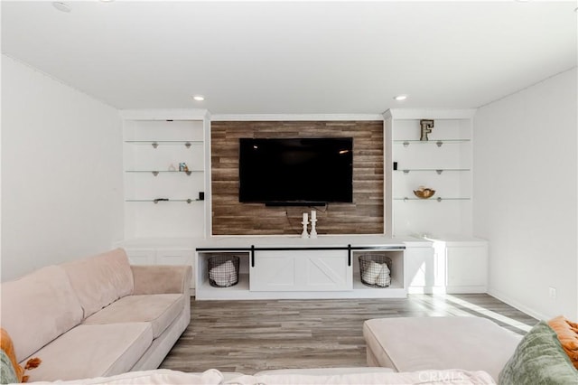 living area featuring built in shelves, light wood-style floors, recessed lighting, and baseboards