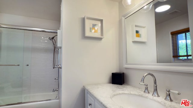 bathroom featuring vanity and combined bath / shower with glass door