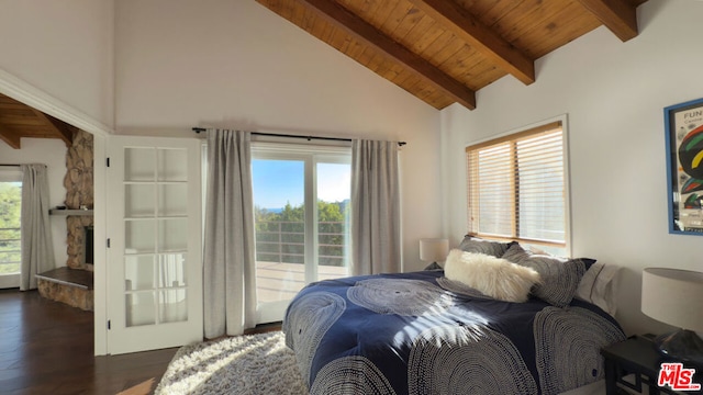 bedroom with wood ceiling, a stone fireplace, dark wood-type flooring, and multiple windows