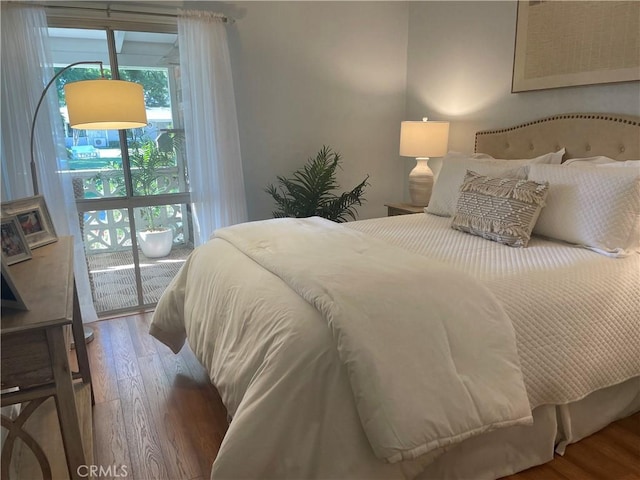 bedroom featuring access to outside and hardwood / wood-style flooring