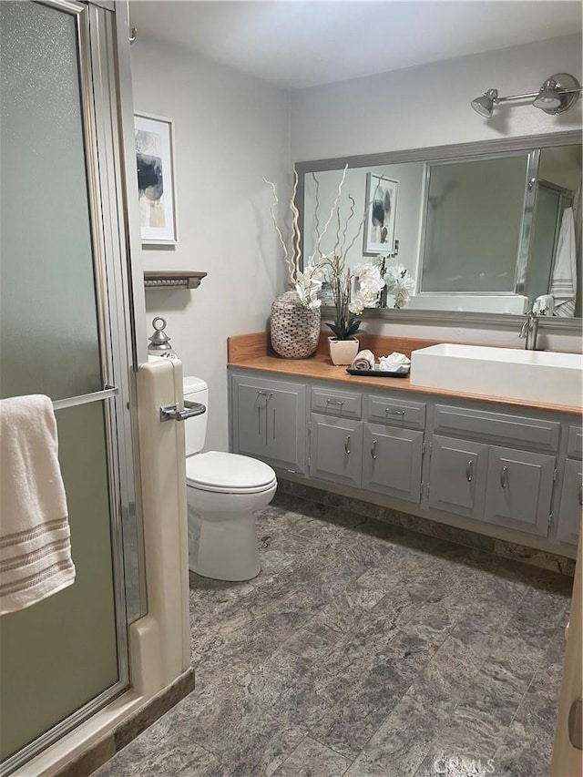 bathroom with vanity, toilet, and an enclosed shower