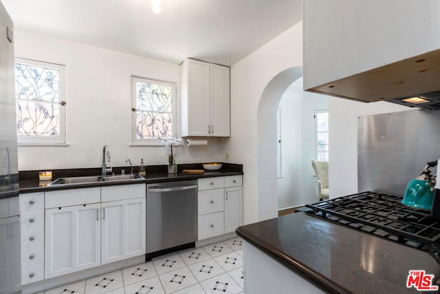 kitchen featuring sink, white cabinets, stainless steel dishwasher, and a healthy amount of sunlight